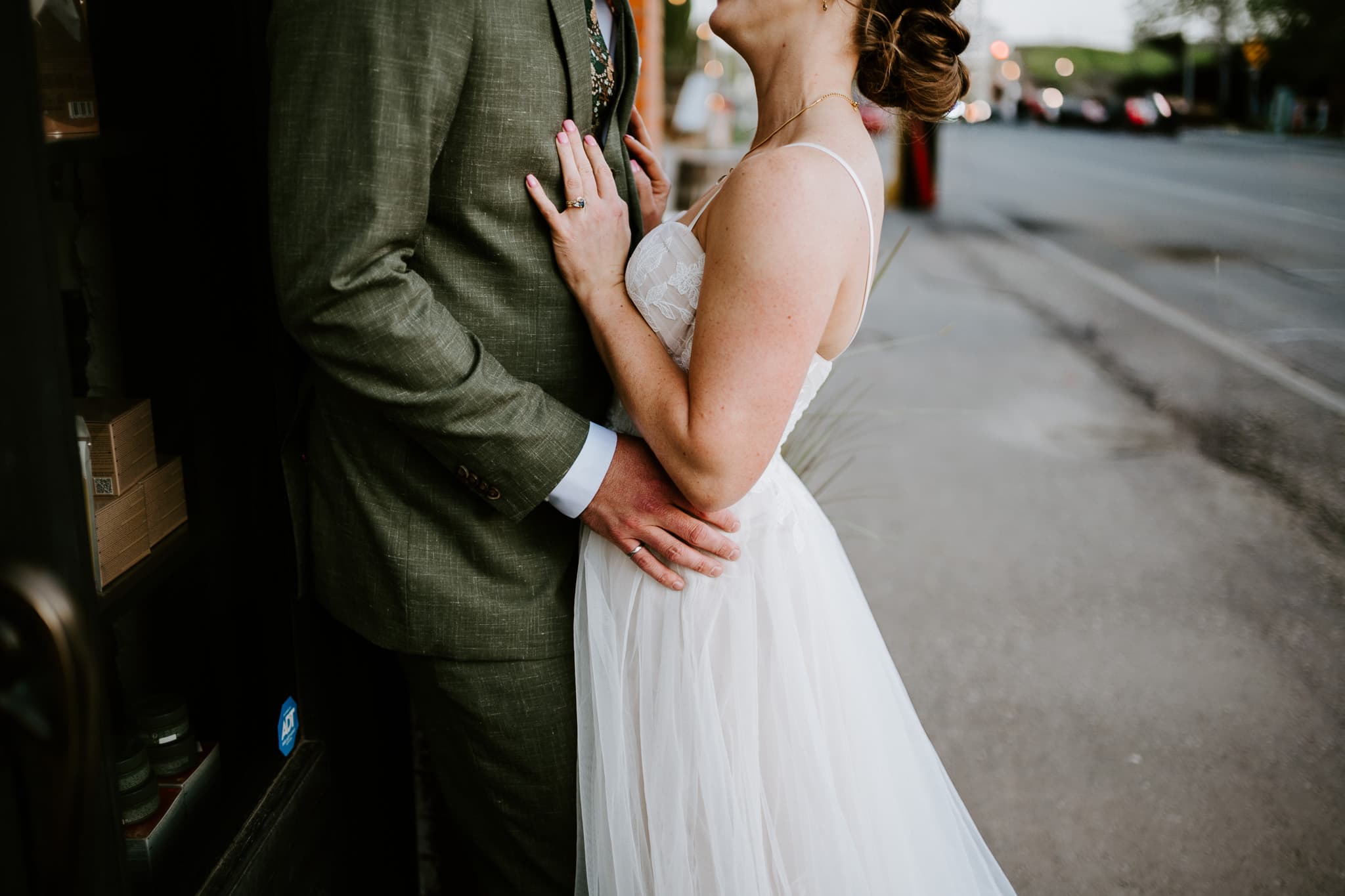 Close detail of the couple holding one another, rings showing